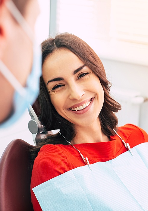 Woman in dental chair smiling at dentist