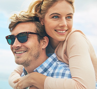 Man and woman smiling after metal free dental restorations