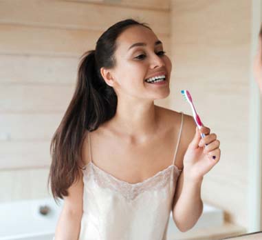 Woman brushing her teeth to prevent toothaches in Charleston