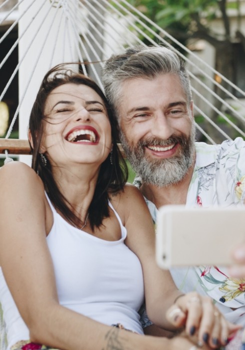 Man and woman laughing after dental implant tooth replacement