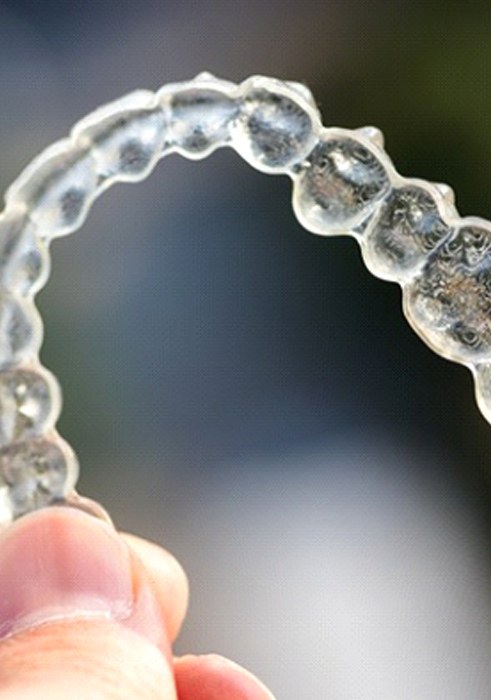 Closeup of Invisalign in Daniel Island aligner on colorful background