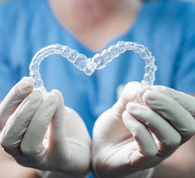 Dentist holding Invisalign in Daniel Island in heart shape