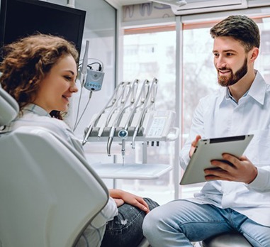 dentist showing a patient a tablet 