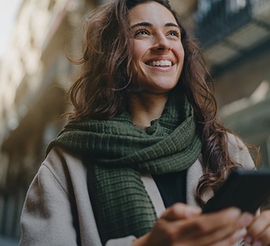 a smiling person with their phone in their hand