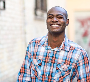 a person smiling and standing outside